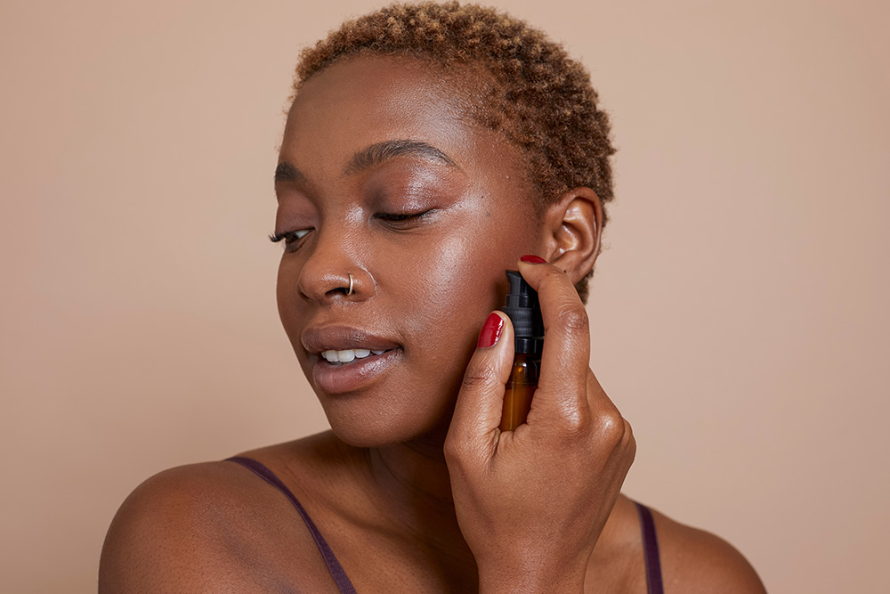 mujer negra aplicándose retinol
