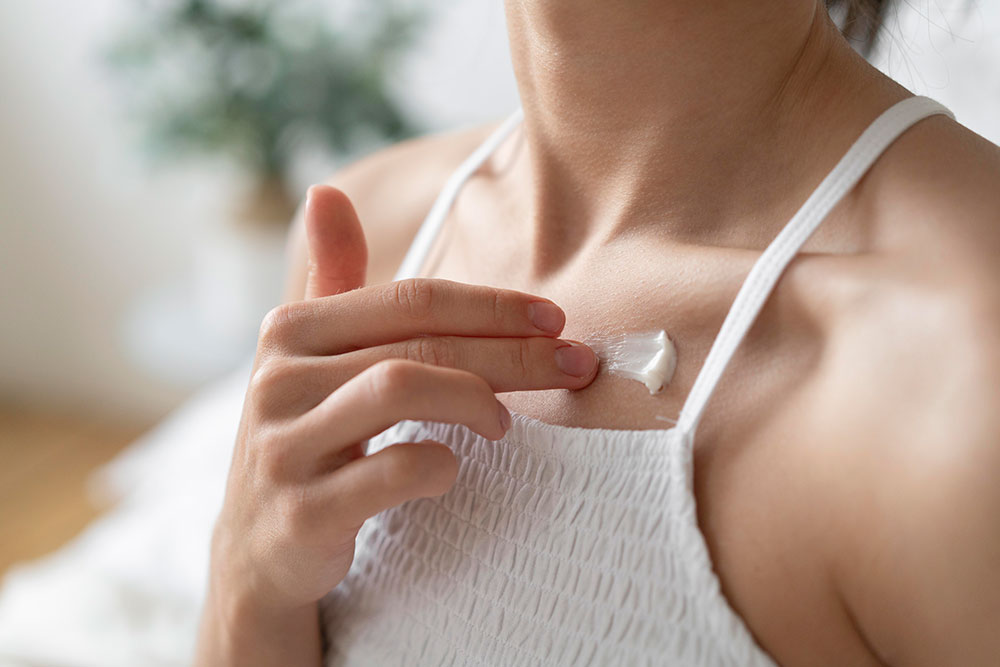 mujer aplicándose crema con vitamina e